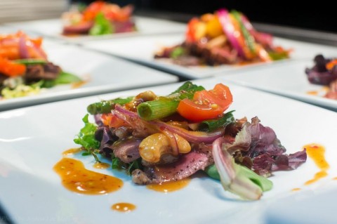 Seared Margret duck with peppers, onion, tomatoes and cashews served a sweet chili vinaigrette