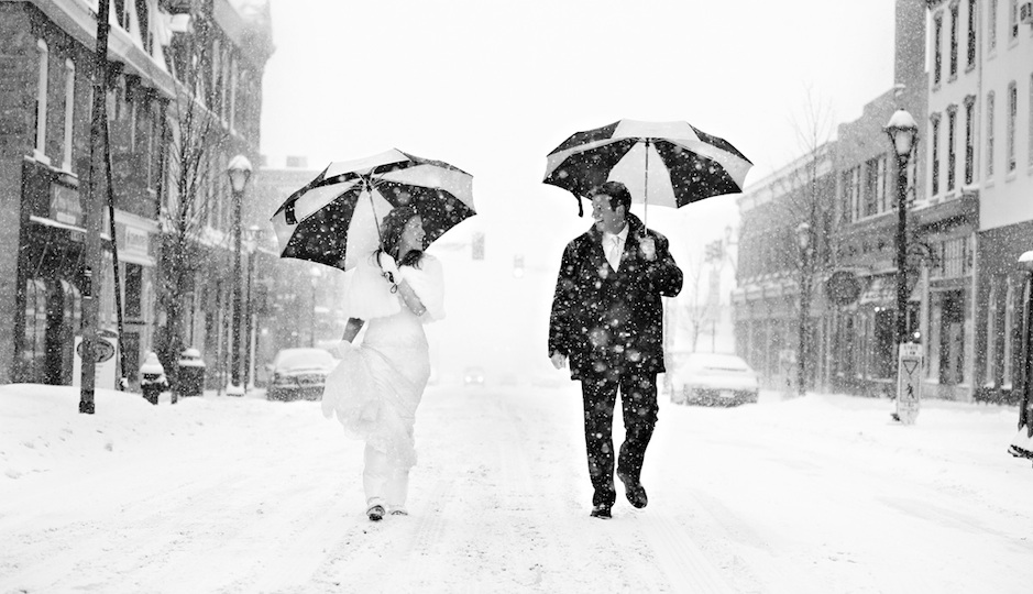 Gretchen and Steve walk along a snow-covered Bridge Street in Phoenixville near their winter wedding at the Phoenixville Foundry. Photo by Phillp Gabriel Photography.