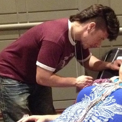 Cutler practicing acupuncture on a client at the Philadelphia Trans Health Conference.