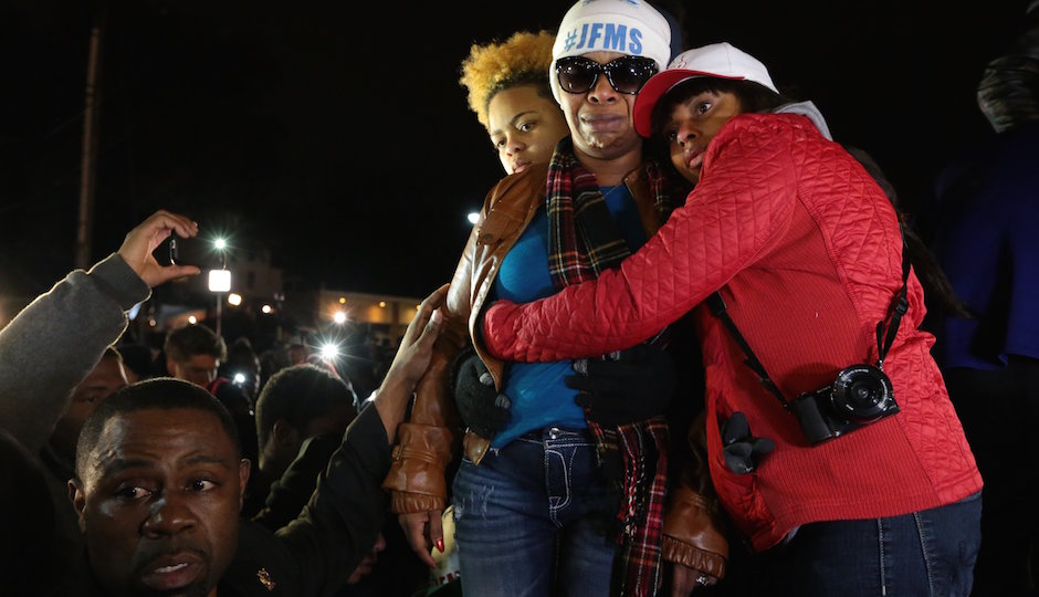 Lesley McSpadden, second from right, Michael Brown's mother, is comforted outside the Ferguson police department as St. Louis County Prosecutor Robert McCulloch conveys the grand jury's decision not to indict Ferguson police officer Darren Wilson in the shooting death of her son, Monday, Nov. 24, 2014, in Ferguson, Mo. (AP Photo/St. Louis Post-Dispatch, Robert Cohen)