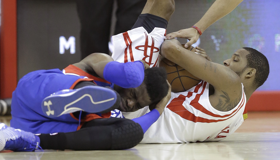 Philadelphia 76ers' Nerlens Noel, left, holds his head after scrambling for a ball against Houston Rockets' Trevor Ariza, right, in the second half of an NBA basketball game Friday, Nov. 14, 2014, in Houston. The Rockets won 88-87.(AP Photo/Pat Sullivan)