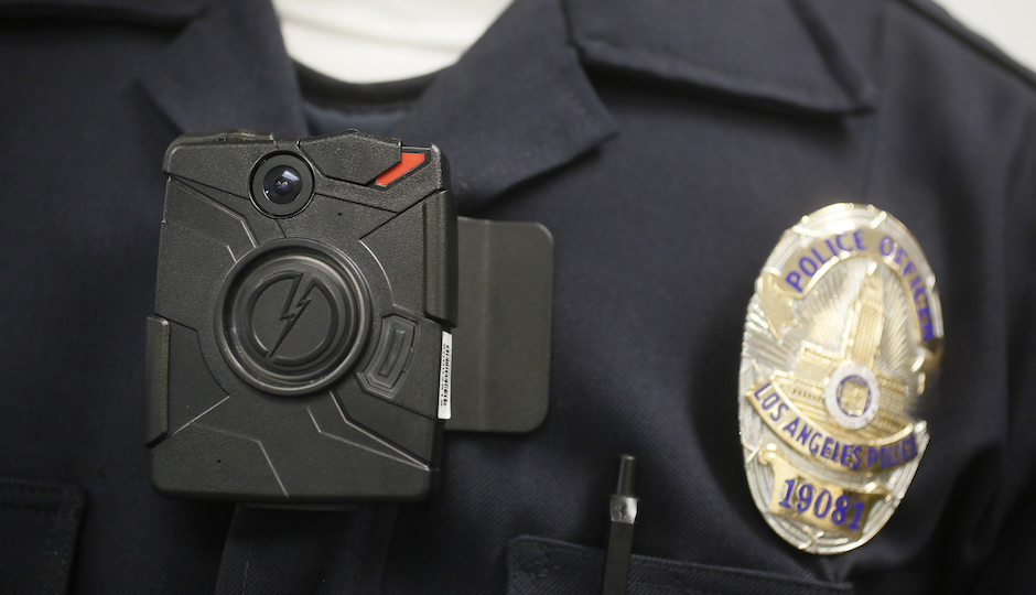 This Jan. 15, 2014 file photo a Los Angeles Police officer wears an on-body cameras during a demonstration for media in Los Angeles. Officers in one of every six departments around the country are now patrolling with these tiny cameras on their chests, lapels or sunglasses, and that number is growing. Most civil libertarians support their expansion despite concerns about the development of policies governing their use and their impact on privacy. (AP Photo/Damian Dovarganes,File)