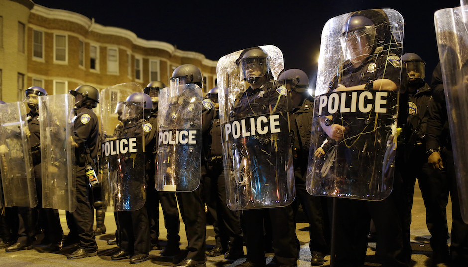 Police stand in formation as a curfew approaches, Tuesday, April 28, 2015, in Baltimore, a day after unrest that occurred following Freddie Gray's funeral. (AP Photo/Patrick Semansky)
