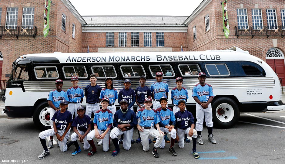 Members of the 2014 Taney Little League-Anderson Monarchs teams pose for a photo with their team bus in front of the Baseball Hall of Fame on Thursday, Sept. 25, 2014, in Cooperstown, N.Y. Pitcher Mo'ne Davis is fourth from left. 