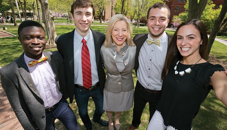 Amy Gutmann with four graduating seniors on College Green, April 29, 2015.