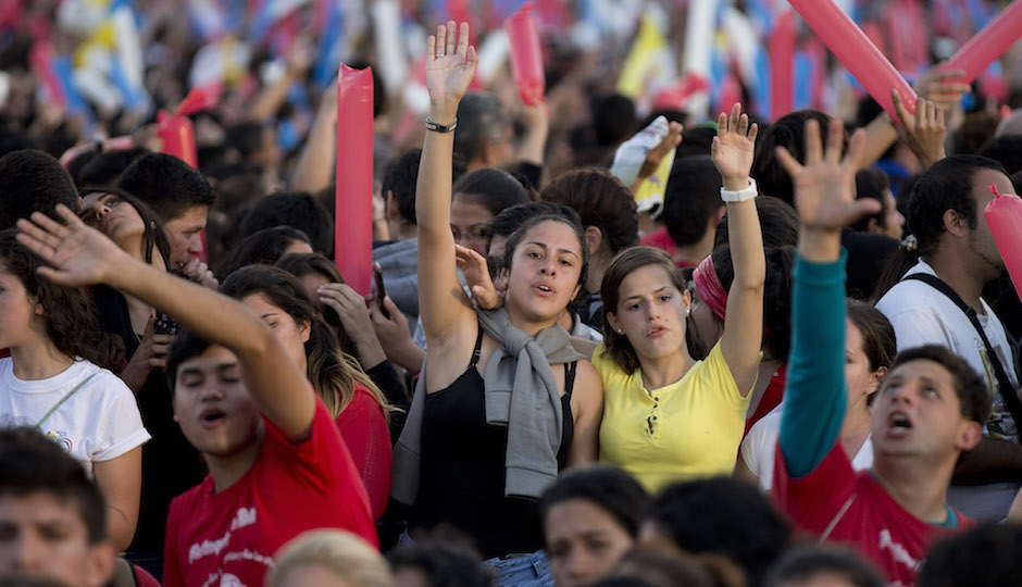 People pray and sing before Pope Francis arrives to a meeting with the young in Asuncion, Paraguay, Sunday, July 12, 2015. The Pope addressed tens of thousands of young people waiting for him at a venue along the banks of the Paraguay River. Up to 2 million people are expected in Philadelphia for the pope's September visit (AP Photo/Natacha Pisarenko)