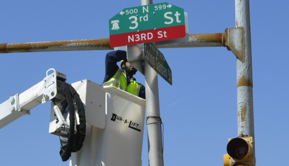 A streets department worker installs N3rd St sign at the Spring Garden intersection. (Tracy Levesque/Wikimedia Commons)