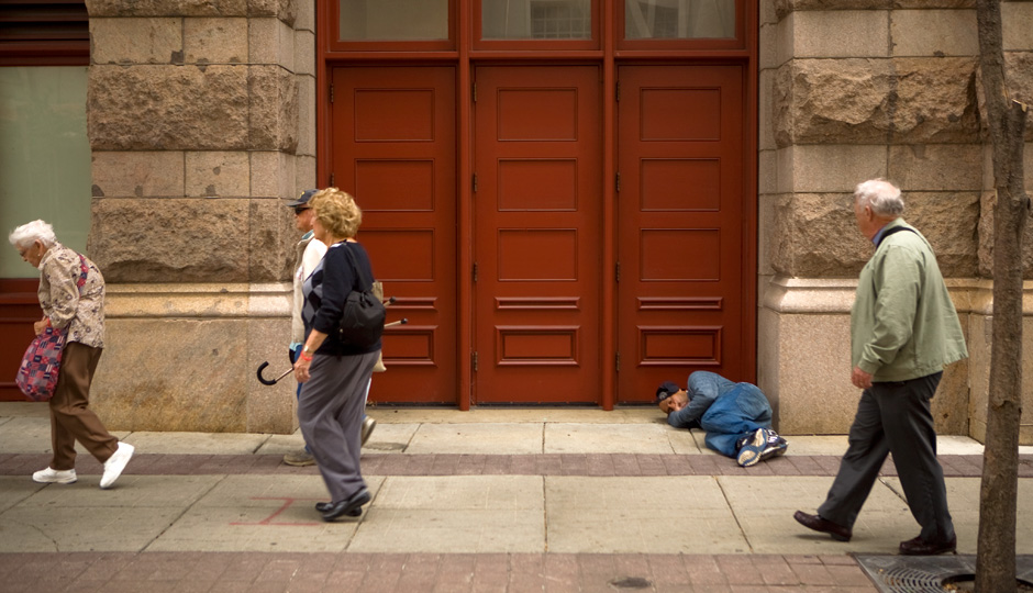 Tourists walk past a homeless person during Pope Francis' visit to Philadelphia. Photo | Bradley Maule