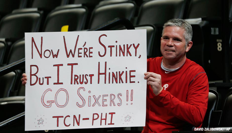 Philadelphia 76ers fan and Bucks County, Pa., native Andy Atkinson, who now lives in Denver, waves a placard in support of 76ers general manager Sam Hinkie's rebuilding effort as the Sixers take the court to face the Denver Nuggets in the first quarter of an NBA basketball game Wednesday, March 25, 2015, in Denver. 