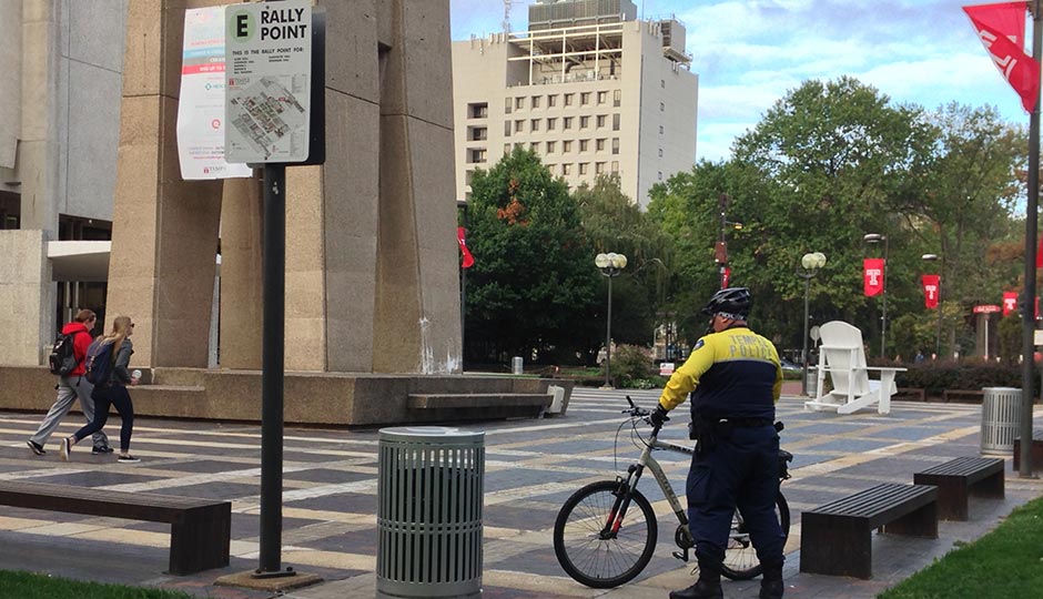 A Temple University Police Bike Officer stands guard at the Bell Tower, the epicenter of campus, earlier this morning. Photo | Rob DiRienzo