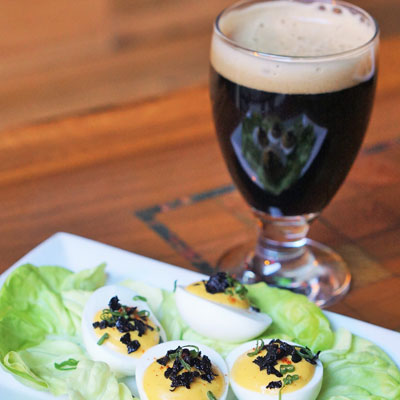 Black truffle deviled eggs and a black beer at Bru | Photo via Bru Craft & Wurst