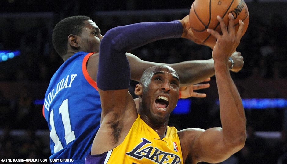 January 1, 2013; Los Angeles, CA, USA; Los Angeles Lakers shooting guard Kobe Bryant (24) grabs a rebound in front of Philadelphia 76ers point guard Jrue Holiday (11) in the second half of the game at the Staples Center. 76ers won 103-99.