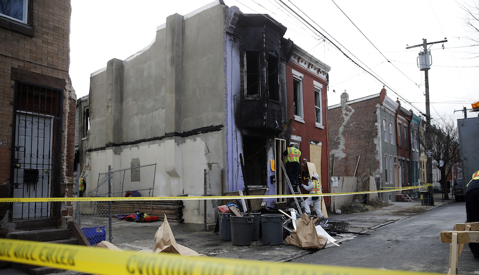 City workers board up the scene of a fatal fire Friday, Jan. 8, 2016, in Philadelphia. A pregnant mother ran into her burning row house to rescue her toddler Friday morning but died along with the child when smoke prevented their escape, officials said. (AP Photo/Matt Rourke)