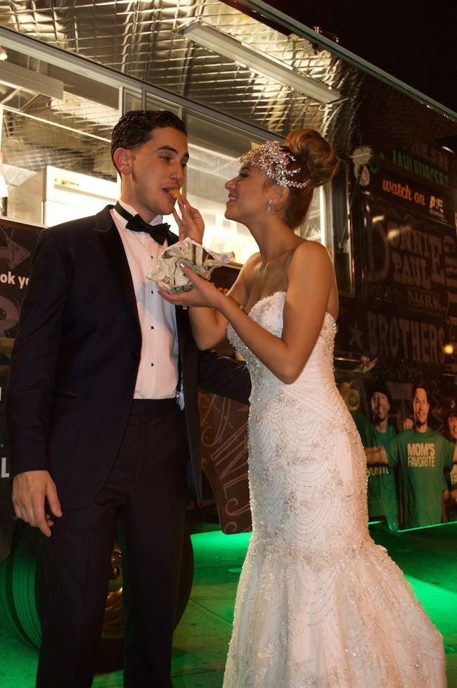 Marissa Patterson and Justin Fiordimondo snack on treats from the Wahlburgers truck at their VIE wedding this past fall. Photo by Sarah Christiansen.