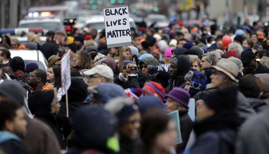 A large crowd marches to mark the holiday honoring the Rev. Martin Luther King Jr., Monday, Jan. 19, 2015, in Philadelphia, Pa. Participants called for a higher minimum wage, an end to police "stop and frisk" tactics and a locally controlled school system. (AP Photo/Mel Evans)