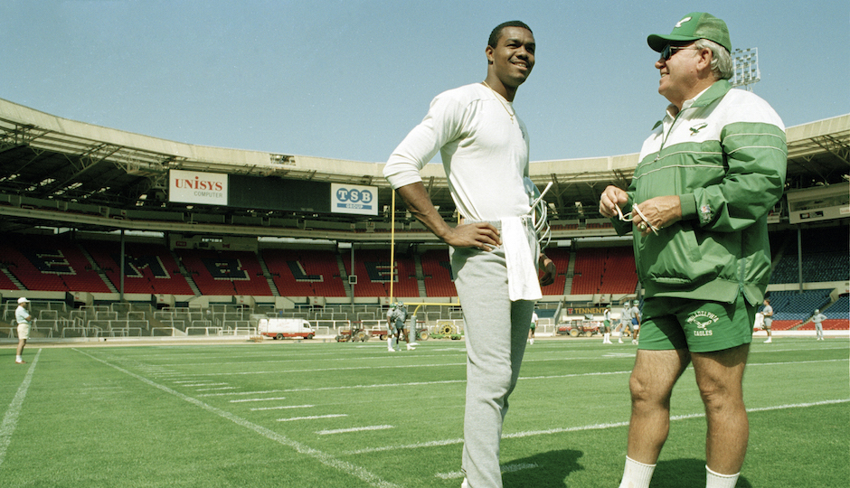Randall Cunningham, quarterback for the Philadelphia Eagles talks with head coach Buddy Ryan during a light training session, Aug. 5, 1989, at London's Wembley Stadium where they will take on the Cleveland Browns for the 1989 American Bowl. (AP Photo/Gillian Allen)