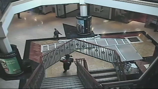 A woman identified as 32-year-old Cherie Amoore walks through and out of the King of Prussia mall with seven-month-old