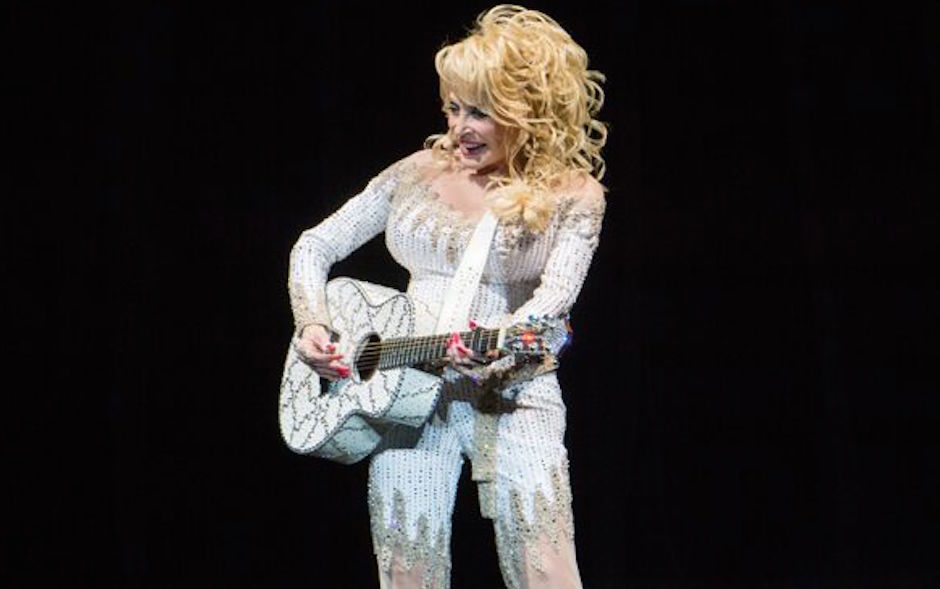 Dolly Parton strums her guitar on stage at the Mann Center in Philadelphia