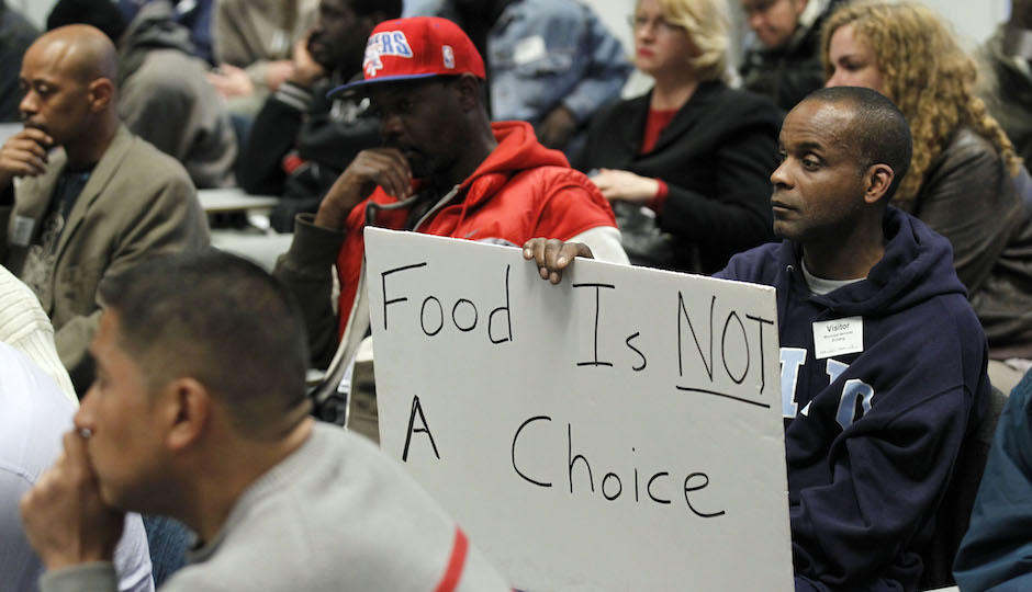 A man holds a sign during a Philadelphia Department of Public Health hearing in reference to regulations banning outdoor food distribution Thursday, March 15, 2012 in Philadelphia. (AP Photo/Alex Brandon)