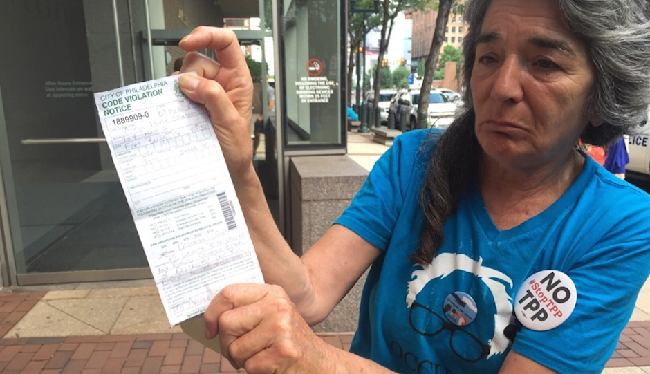 Anna Marie Sternberg displays her code violation citation in front of the federal courthouse in Philadelphia. (Photo by Brian Thomas)