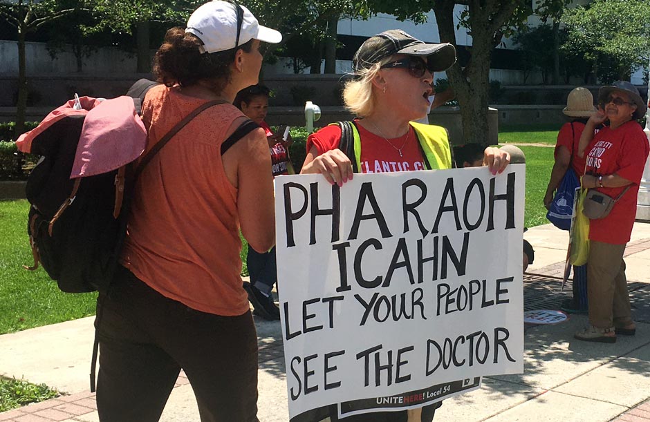 A striking union worker outside the Trump Taj Mahal in Atlantic City holds a sign that reads 'Pharaoh Icahn: Let your people see the doctor.'