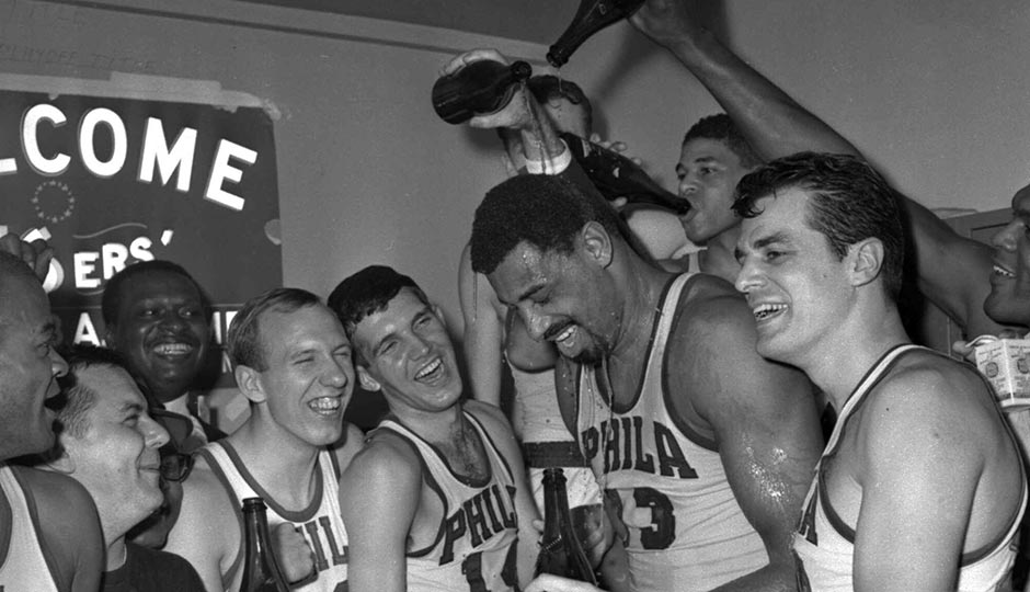 Wilt Chamberlain of the Philadelphia 76ers gets champagne poured on him on April 12, 1967, in the 76ers dressing room after Philadelphia defeated the Boston Celtics 140-116 to win the Eastern Division NBA championship. Surrounding Chamberlain are from the left are Bob Weiss, Matt Guokas, Wally Jones and Dave Gambee. AP Photo