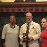 Kelly Lee, Jerry Pinkney, and Sheila Hess pose with the award that was presented to Pinkney this afternoon.