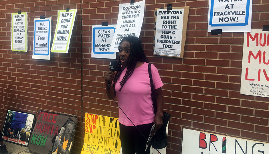 ramona africa standing in front of posters supporting mumia abu-jamal