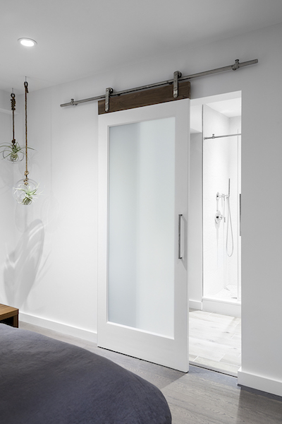 A sliding translucent glass door makes the bathroom brighter by letting in natural light.
