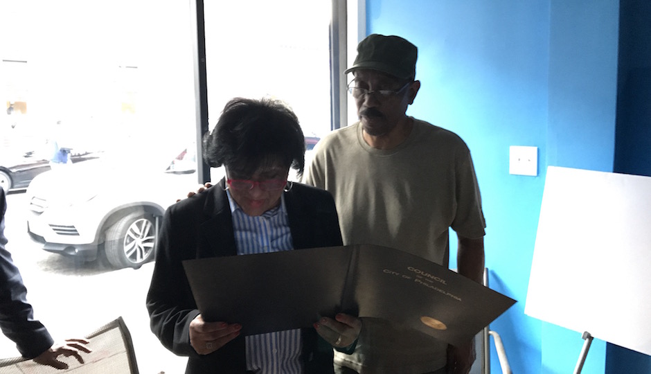 Councilwoman Jannie Blackwell (left) reading the City Council citation honoring Ronald Brooks (right)