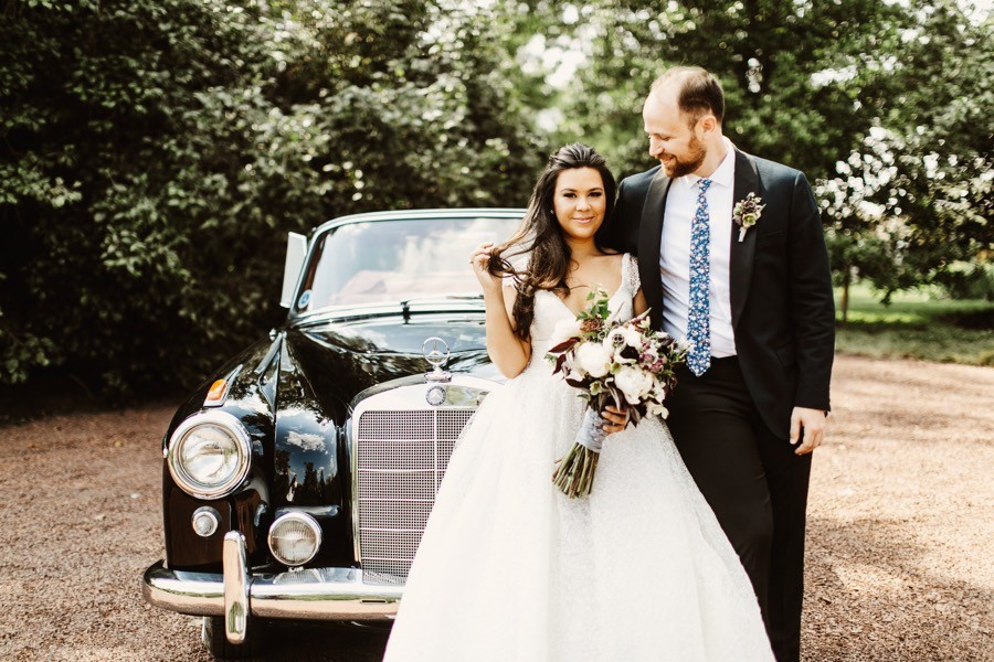 bride and groom with vintage getaway car