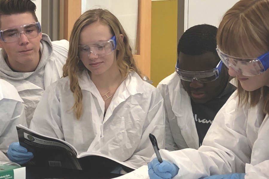 Students in white coats in the lab