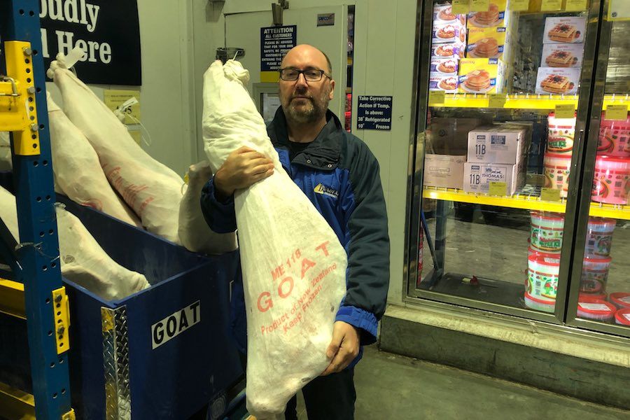 man holds a frozen goat at restaurant depot during the coronavirus crisis in philadelphia