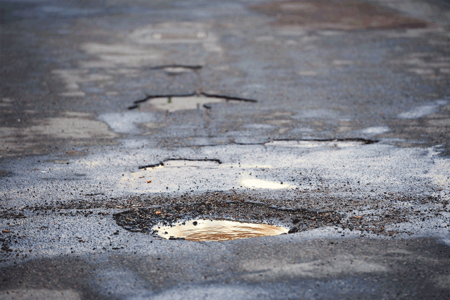 an animated gif of an orange traffic cone being placed on a pothole in Philadelphia