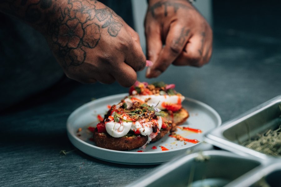 Elijah Milligan, chef at Rosemary in Delco's Ridley Park, putting the finishing touches on a burrata toast dish