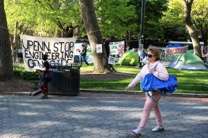 A woman walks by the encampment of protesters at the University of Pennsylvania on Saturday