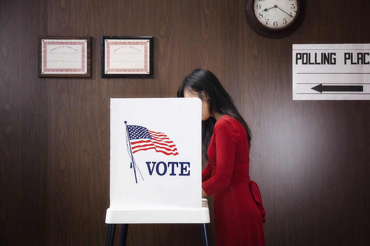 Stock image of a woman voting in private