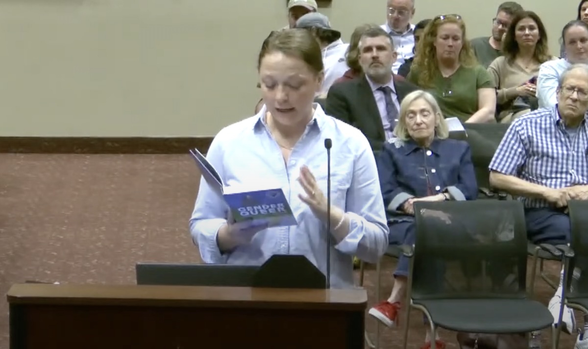 Radnor resident Katherine Barrett-Risk holding a copy of the book Gender Queen at a Radnor Township school board meeting on Tuesday
