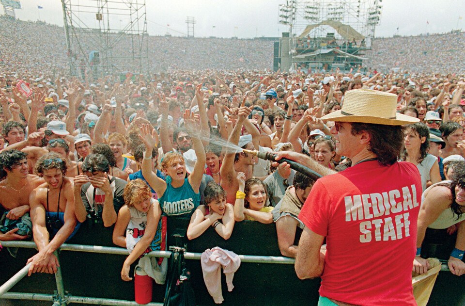 A medical staffer sprays Live Aid fans with cool water at JFK Stadium in Philadelphia (Getty Images)