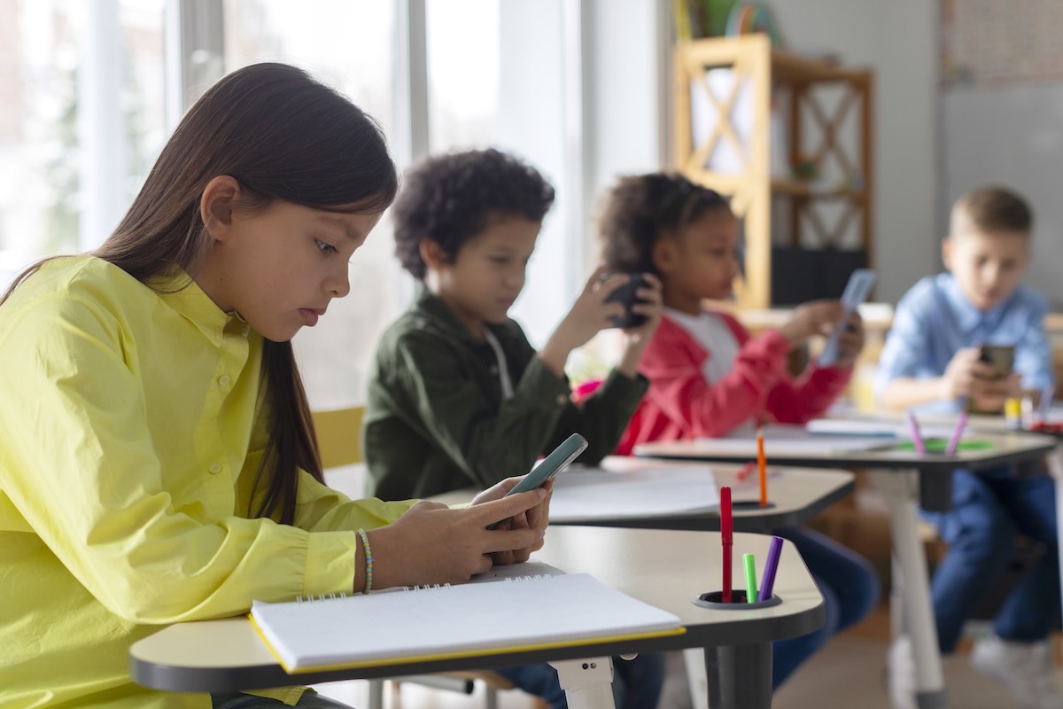 A stock image of school children using cell phones in the classroom, something that wouldn't be allowed if a cell phone ban goes through in Pennsylvania.